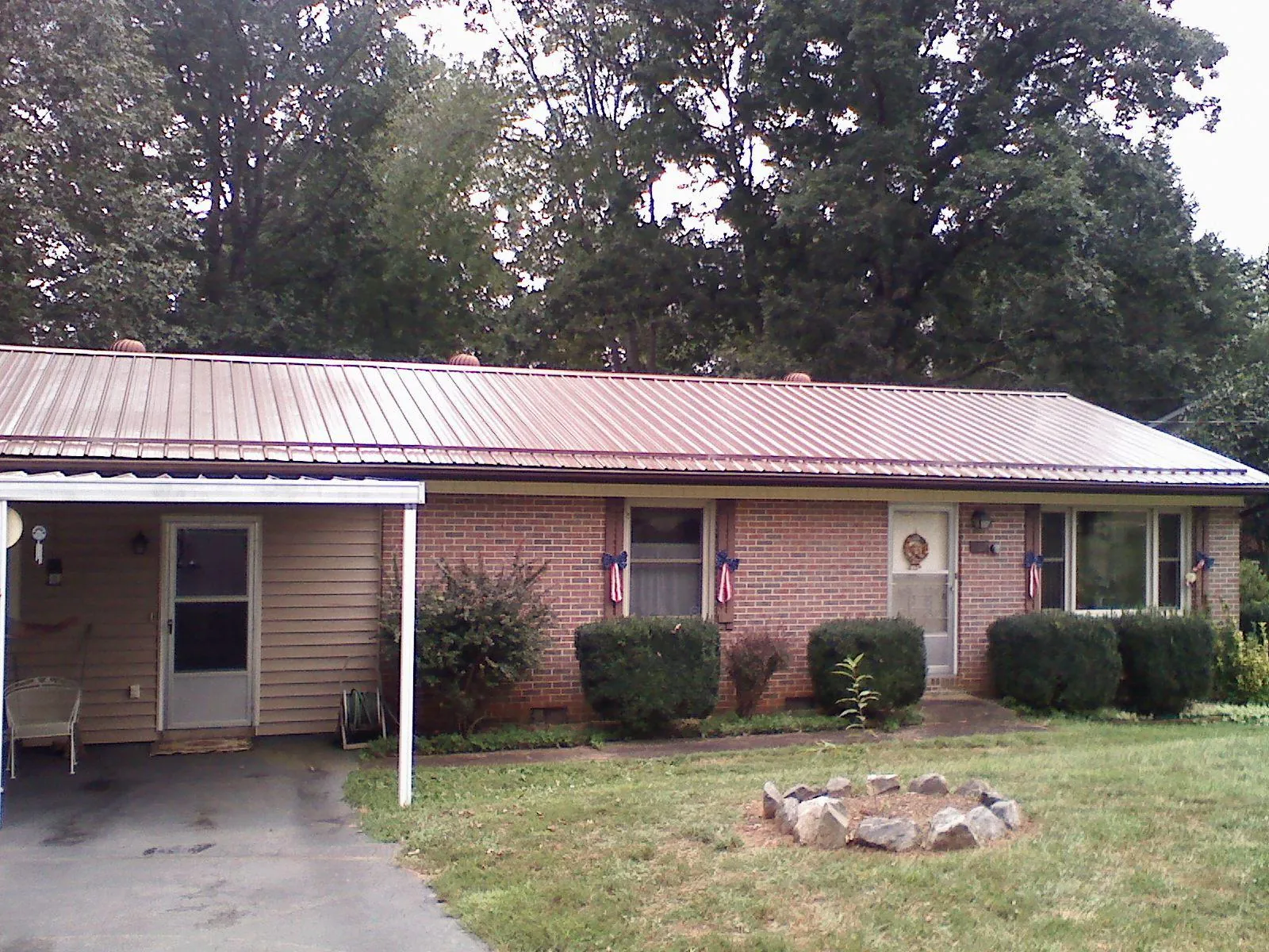 Bronze metal roof and carport on a brick ranch home — Roof Repair work by our crew in Granville